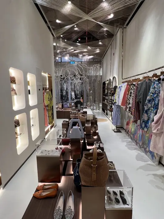 The main aisle of Naseej with clothing rails and mirrored arches