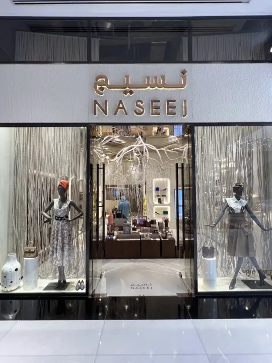 The Naseej storefront at Gate Avenue, with its Arabic and English rose-gold sign and white woven-root window installation